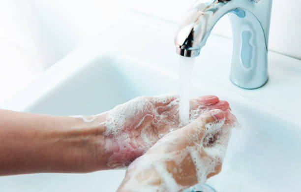 istock Washing hands with soap under running water 1386452738