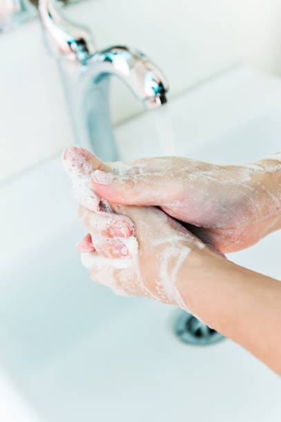 istock Washing hands with soap under running water 1386453388