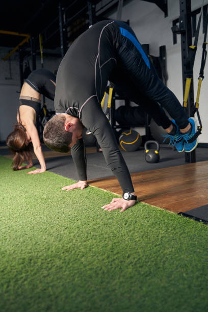 istock Woman and man doing exercise in gym 1386453849