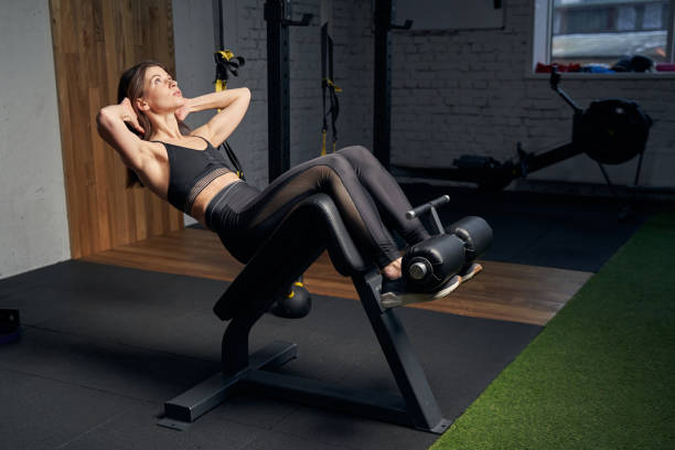 istock Athletic fit woman doing exercise for abs in gym 1386453905