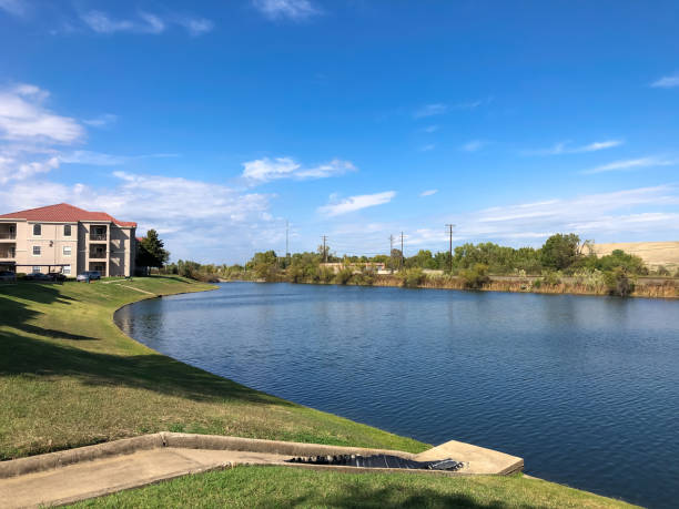 bassin de rétention dans un quartier d’appartements avec tuyau de drainage en béton à lewisville, texas, amérique - retention pond photos et images de collection