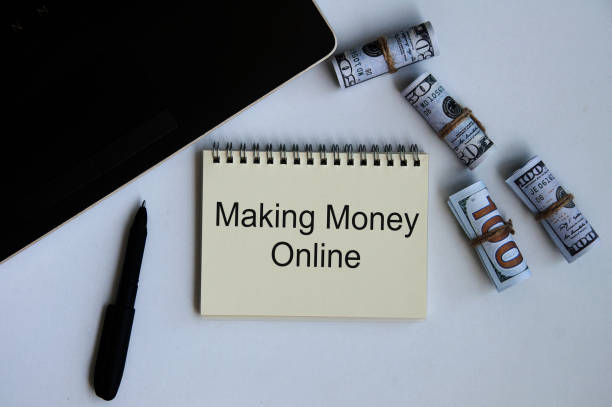 istock Making money online text on notepad with money and laptop background. 1386464262