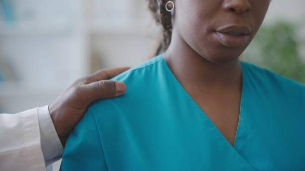 un médecin touche l’épaule d’une collègue, harcèlement sexuel sur le lieu de travail - inappropriate photos et images de collection