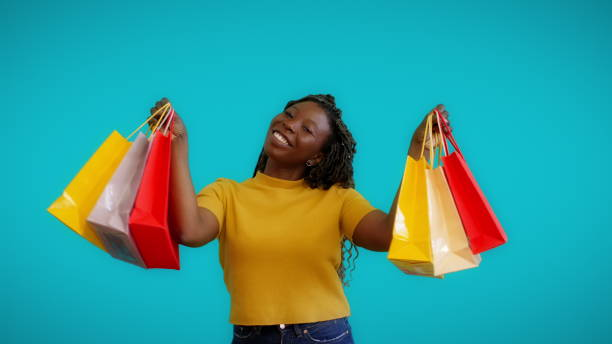 ショッピングバッグ、クリスマ�スプレゼント、季節セールを持っている幸せなアフリカの女性 - spending money adult african ethnicity bag ストックフォトと画像