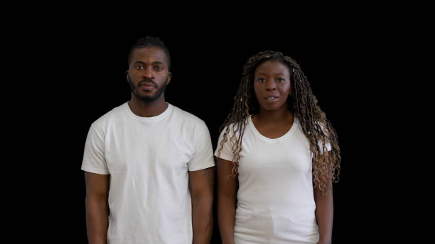 offended interracial couple in knitted sweaters on grey background