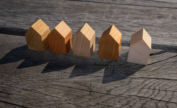 концепция недвижимости. крошечные отдельно стоящие деревянные модели домов в ряд. - modular home стоковые фото и изображения