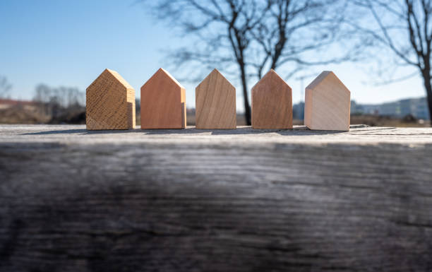 real estate concept. tiny detached wooden houses models in a row. stock photo