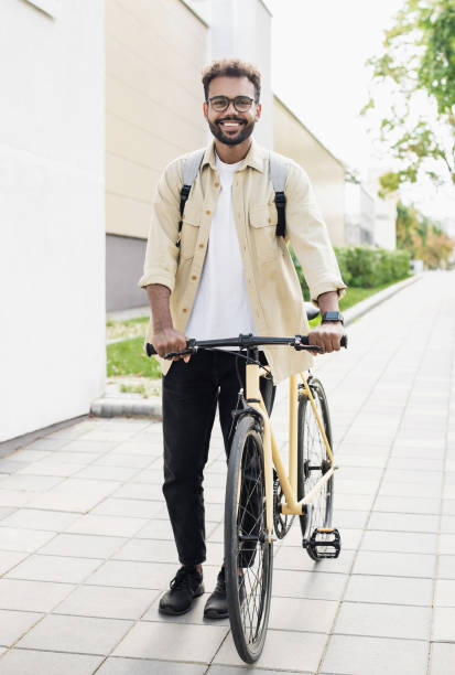 istock Handsome young man with bicycle in a city 1386474580