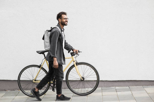 istock Handsome young man with bicycle in a city 1386474596