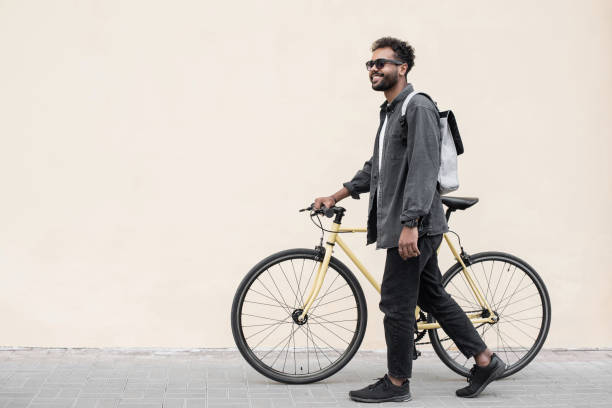 istock Handsome young man with bicycle in a city 1386474609