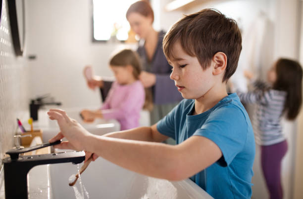 istock Mother with three little children in bathroom, morning routine concept. 1386476992