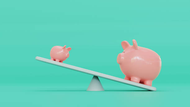 Two pink piggy banks stand on balance board Concept of saving money. Two piggy banks stand on a balance board. It tips towards the biggest piggy bank. business battle stock pictures, royalty-free photos & images