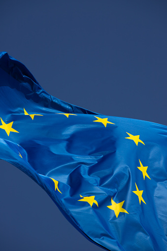 Flag of Europe waving in the wind with a beautiful blue sky in the background. Free place to place text.