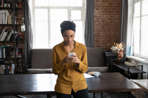 istock Focused African entrepreneur woman in eyeglasses reading text message 1386479269