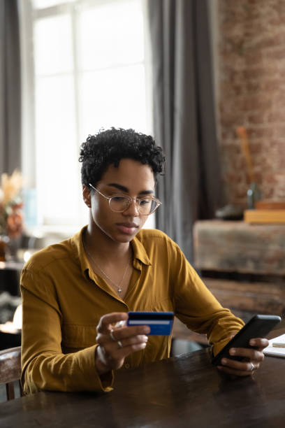 istock Beautiful millennial Afro American customer woman using credit card 1386479295