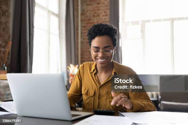 Happy Young Afro American Entrepreneur Woman In Glasses Counting Profit Stock Photo - Download Image Now