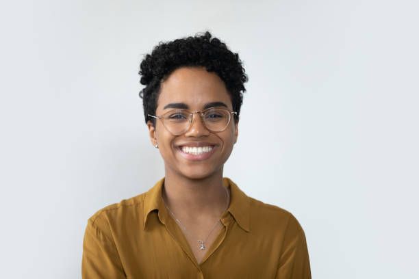 Happy millennial Afro American business woman posing isolated on white Happy millennial Afro American business woman in casual glasses posing isolated on white, smiling with perfect white teeth. Confident female customer, professional head shot portrait female stock pictures, royalty-free photos & images