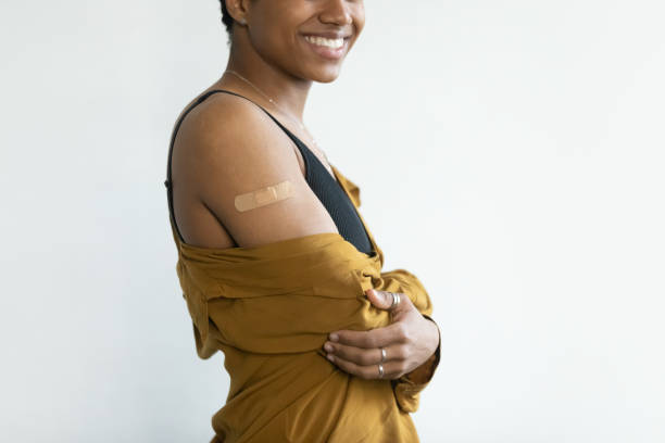 istock Happy Afro American lady showing shoulder with adhesive plaster 1386479330