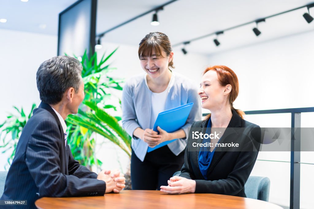 Interpreters and secretaries working in an office Translation Stock Photo