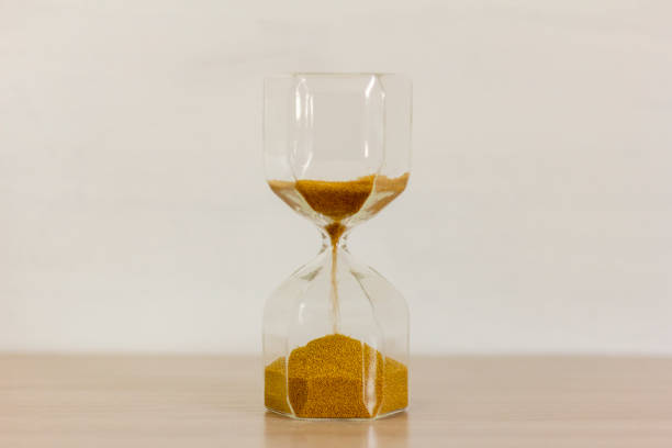 istock An hourglass with golden sand inside on the desktop.Eternal time. 1386486787