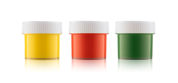 Green, red, yellow gouache jars isolated on white background.