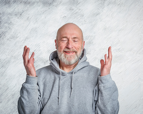 casual, portrait of happy and smiling gesticulating senior man wearing hooded sweatshirt