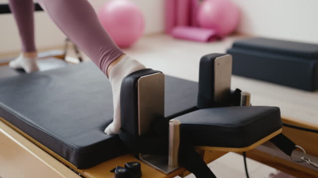 Woman exercising on Reformer machine in Pilates studio