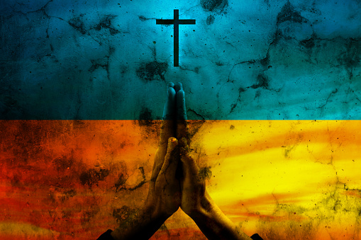 Prayer Hands in Pray in National flag of Ukraine yellow and blue colors. Pray for Ukraine concept.