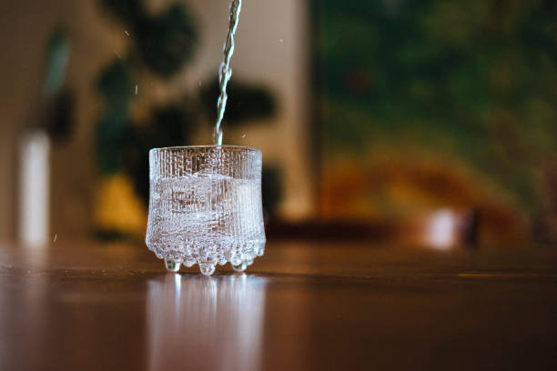 istock Pouring water in a glass on the kitchen table 1386496495