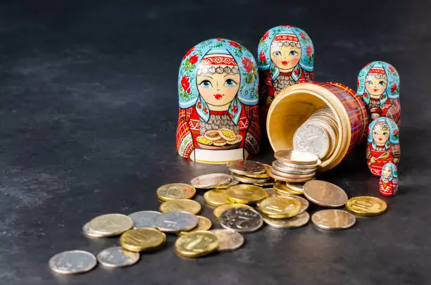 Traditional Russian toy matryoshka and money. Black concrete background. Copy space