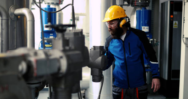 A worker with antiphons works in a heating plant. stock photo