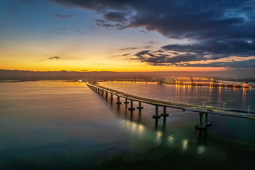 Aerial view of the Bay Bridge with Oakland Harbor in the background at sunrise.