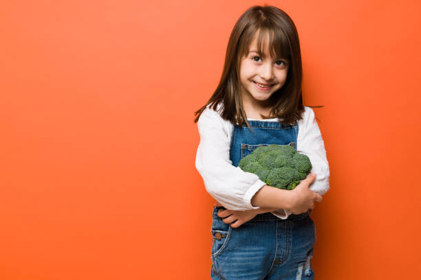 istock Beautiful girl loves broccoli 1386514411