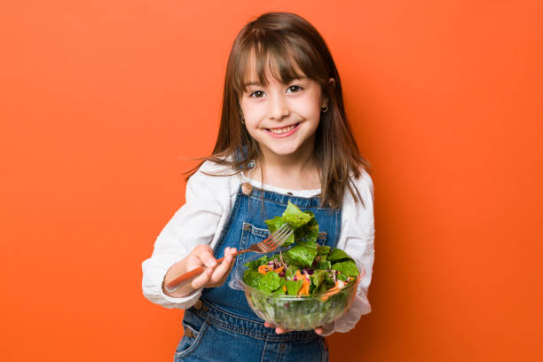 Cute little girl eating a healthy salad stock photo