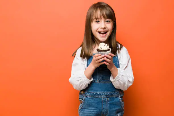 Photo of Happy kid with a chocolate cupcake