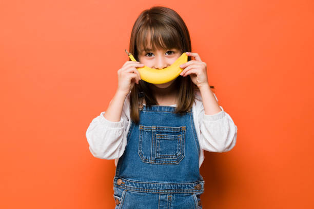 istock Girl having fun with some fruit 1386514965