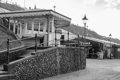 Black and white photo of a seaside shelter on the promenade in the  seaside town of Cromer on the North Norfolk coast