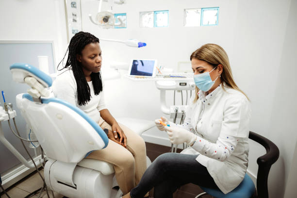 istock Dentist discussing with smiling female patien 1386515803