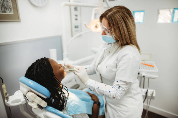 istock Female dentist examining young woman's teeth. 1386515847