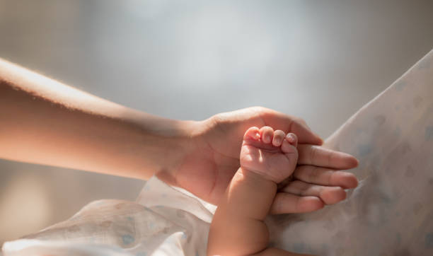 istock mother holding newborn baby hand 1386517979