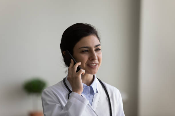 istock Happy young Indian doctor holding cellphone conversation. 1386518031