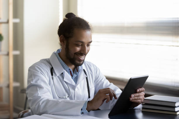 istock Happy young African American doctor using digital tablet. 1386518246