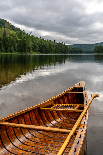 A canoe next to a fishing lake in La Mauricie National park during a cloudy morning of summer in Quebec.