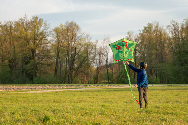A child drops a paper dragon into nature
