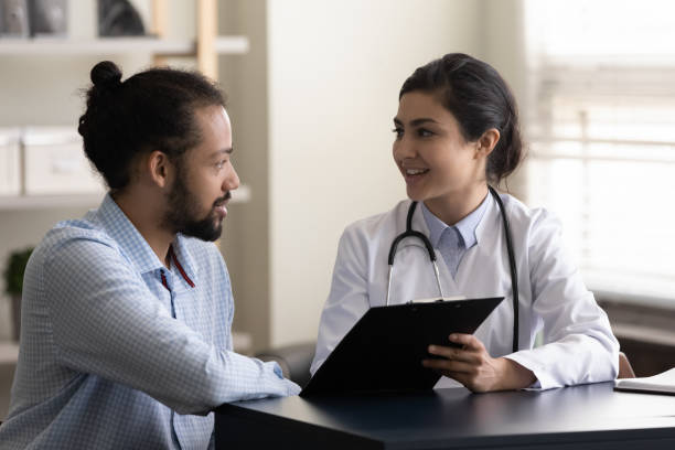 istock Smiling millennial Indian doctor discussing test results with patient. 1386519372