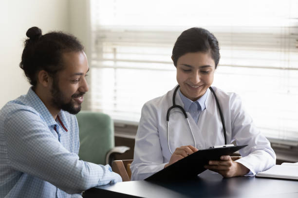 happy young indian doctor communicating with patient. - médico geral imagens e fotografias de stock