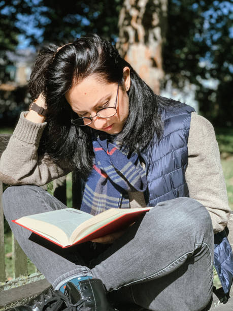 istock Young woman is reading book in park 1386521308
