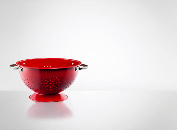 istock Stainless steel red colander on white background 1386523452