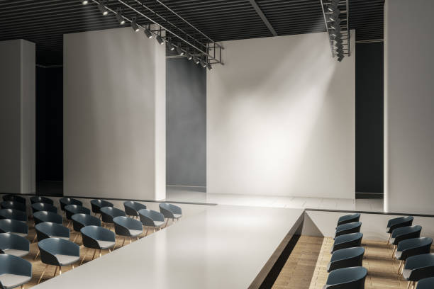 istock Bright concrete auditorium interior with seats, runway and empty mock up place on wall. Presentation and fashion concept. 3D Rendering. 1386528048