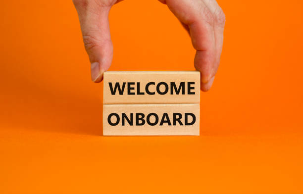 istock Welcome onboard symbol. Wooden blocks with words 'Welcome onboard' on beautiful orange background. Businessman hand. Business and welcome onboard concept. Copy space. 1386532048